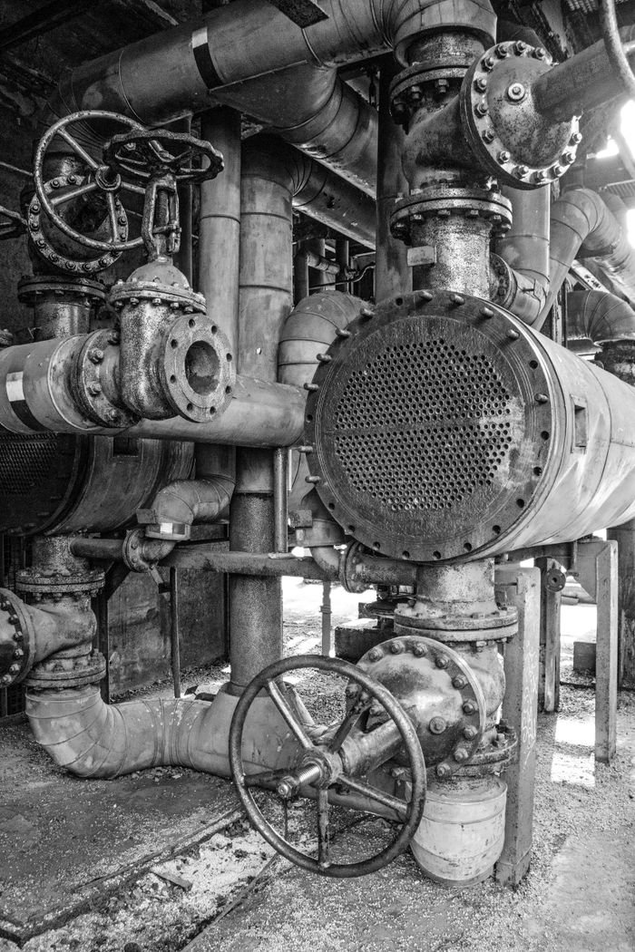 Detailed black and white image of industrial machinery with pipes and valves in NRW, Germany.